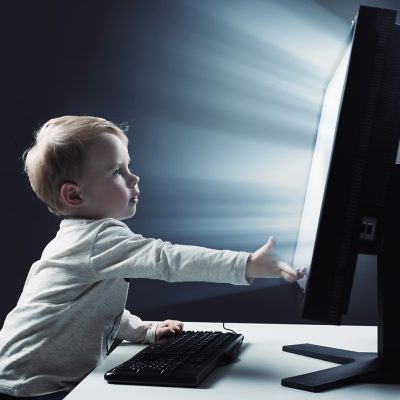 Little,Boy,Child,Sitting,At,Front,Of,A,Big,Monitor